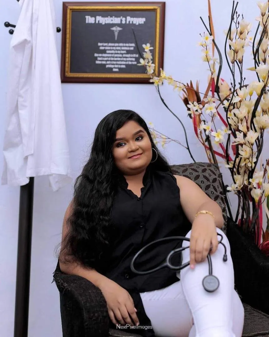An alumna seated with a stethoscope