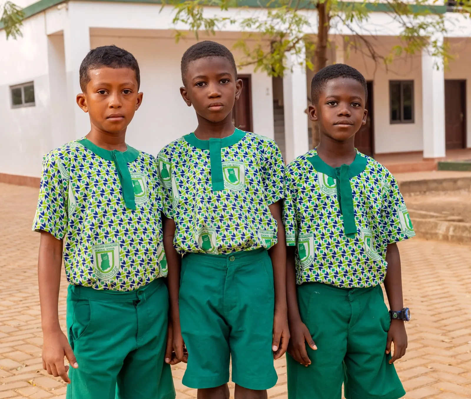 Three boys in the OARS green print uniform
