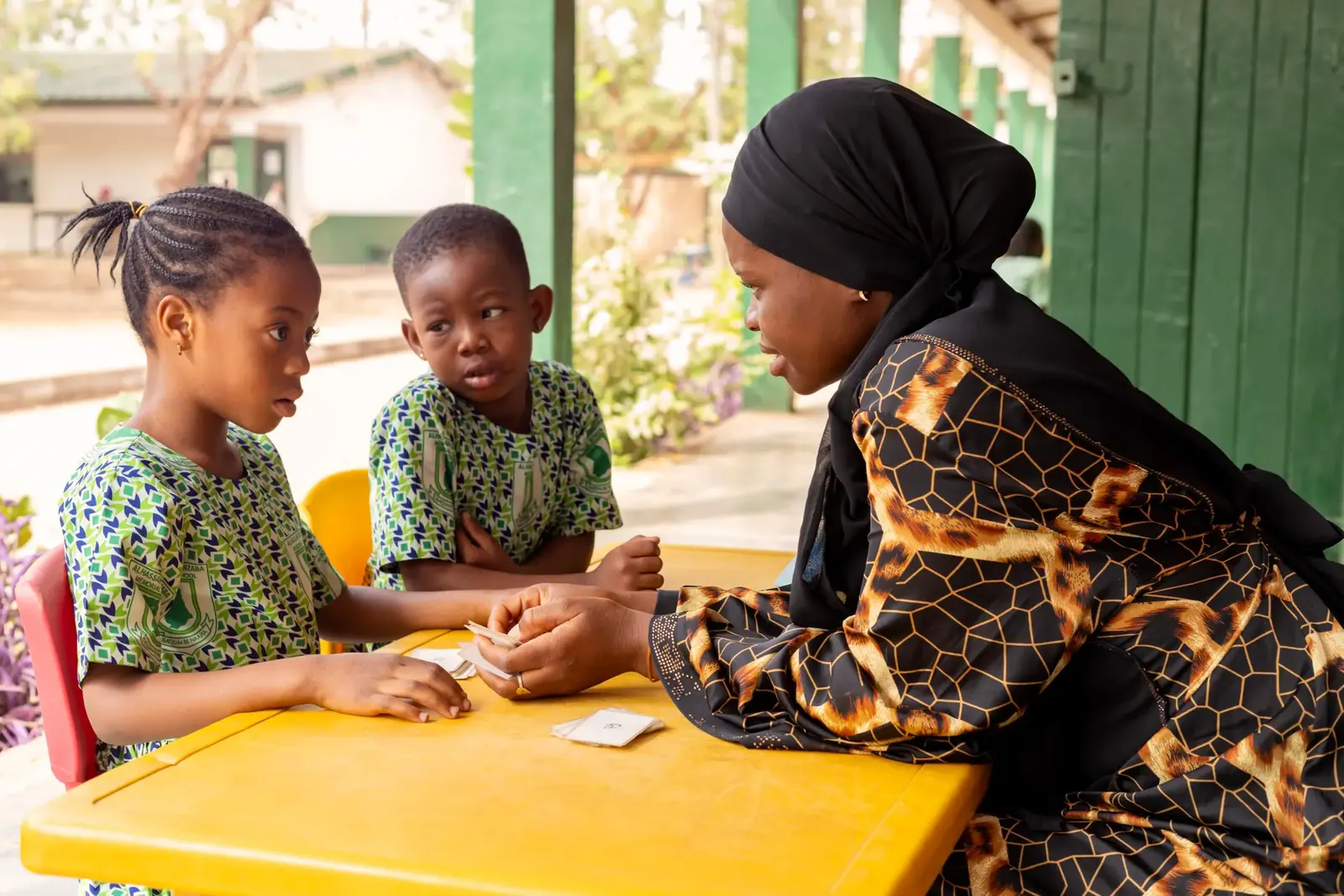A teacher with two kindergarten pupils at a small table