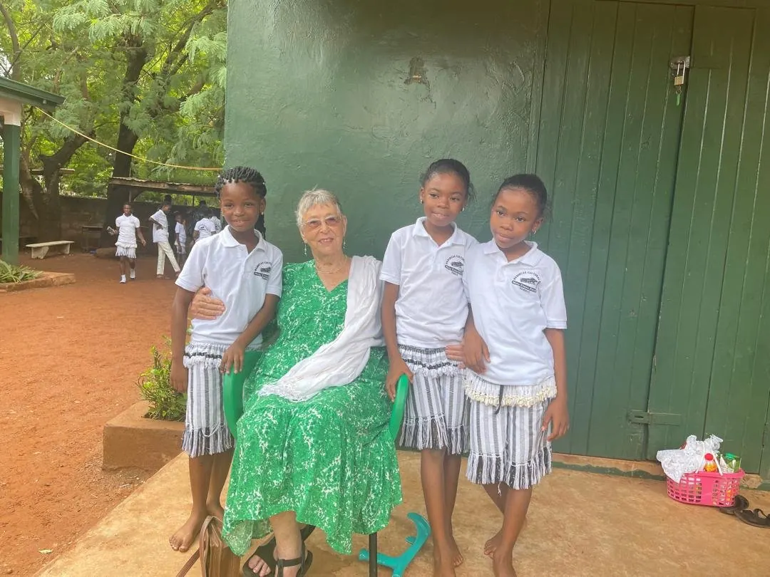 Mrs Jane Alhassan with pupils in the school compound