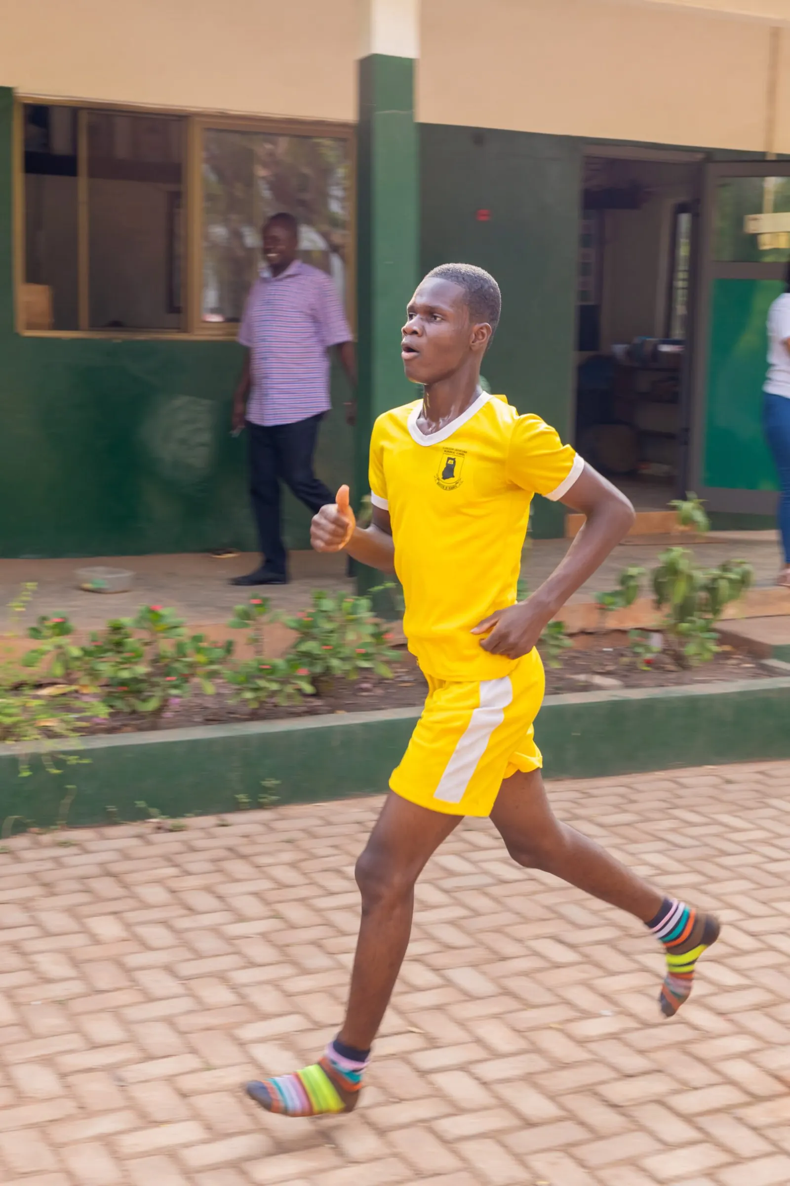 A pupil in yellow sprinting on Sports Day